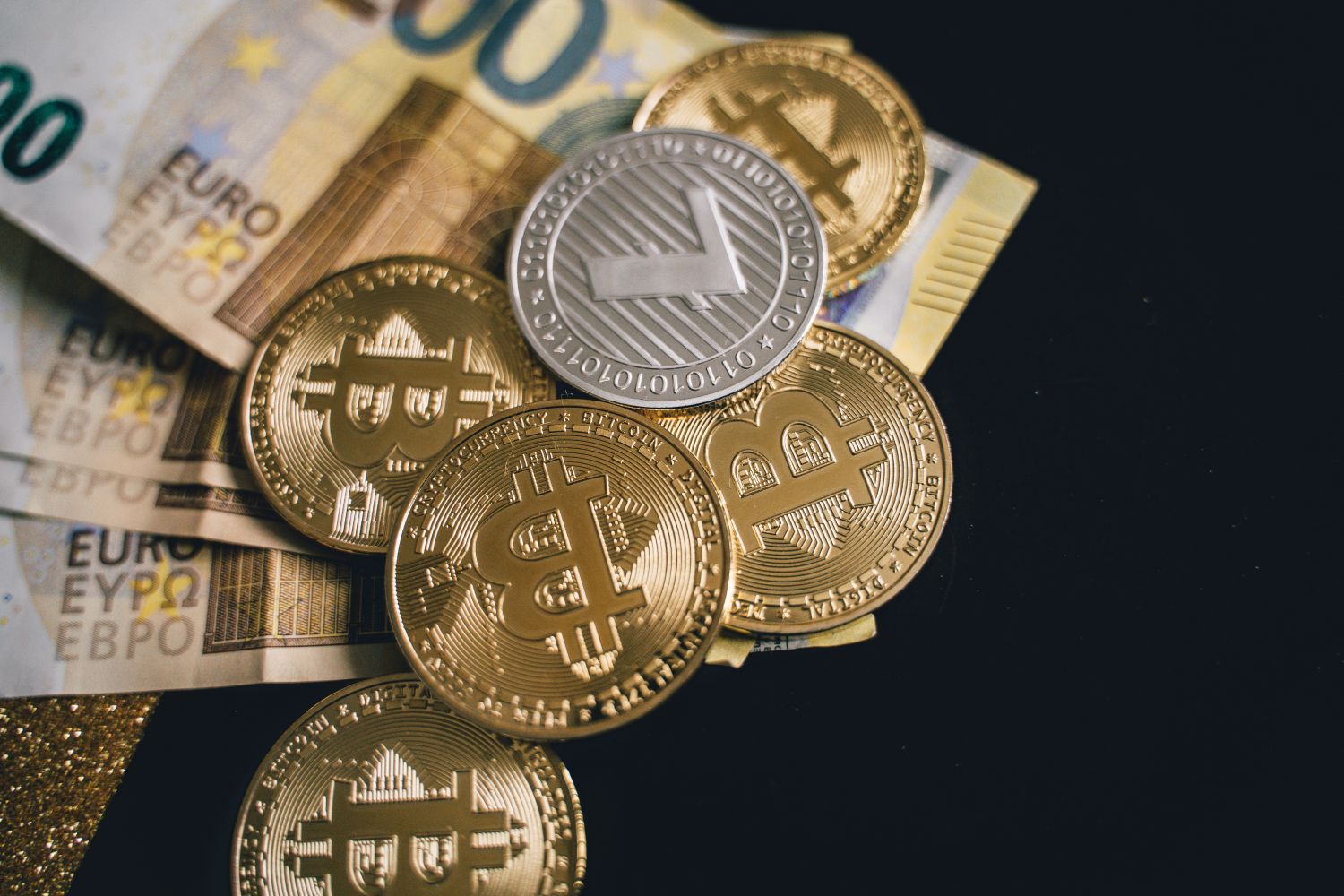 Close-up of bitcoins and euro banknotes, representing modern finance and digital currency exchange.