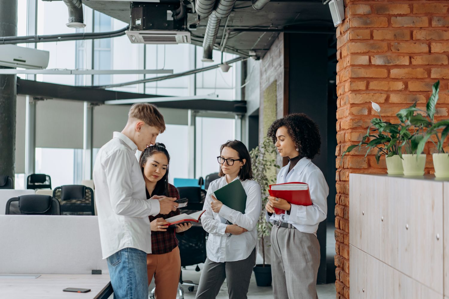 A diverse team of professionals collaborates in a modern office setting, exchanging ideas.